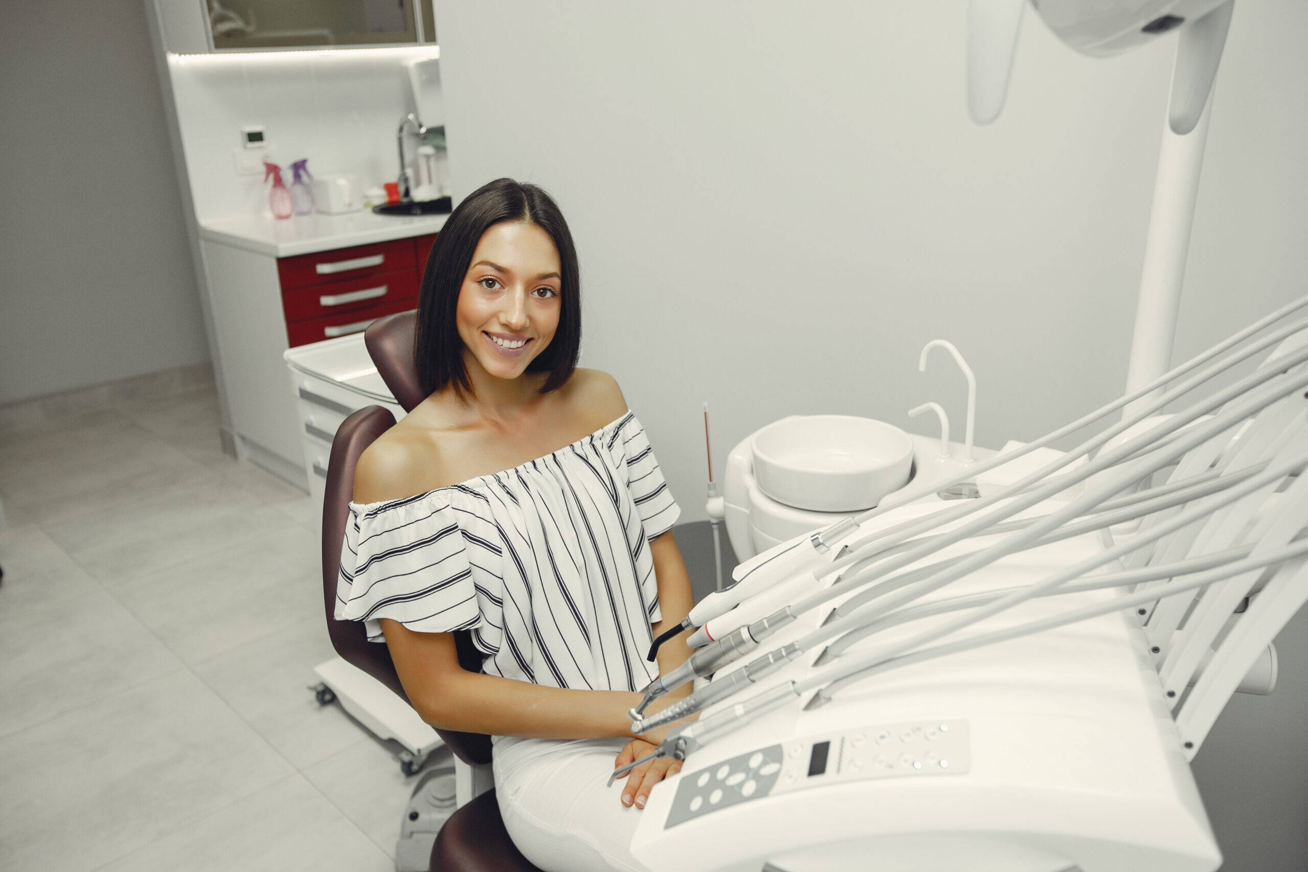 A woman seated in a dental chair, preparing for a dental examination or treatment.