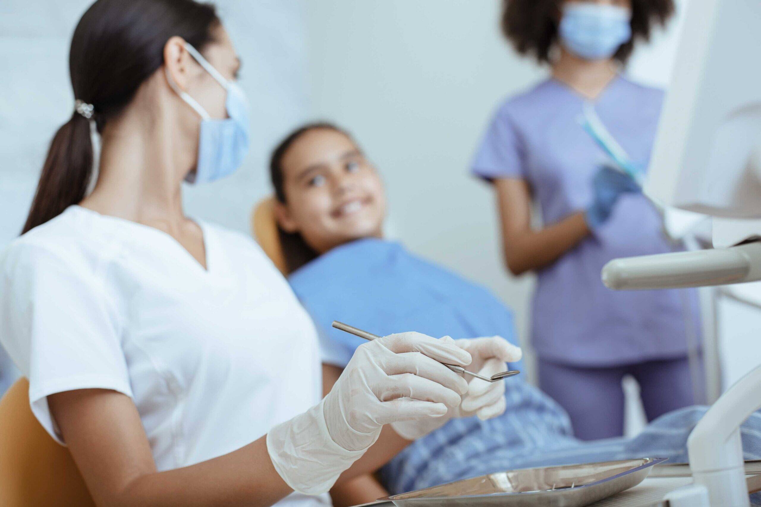 Dentist preparing to examine a smiling child patient.