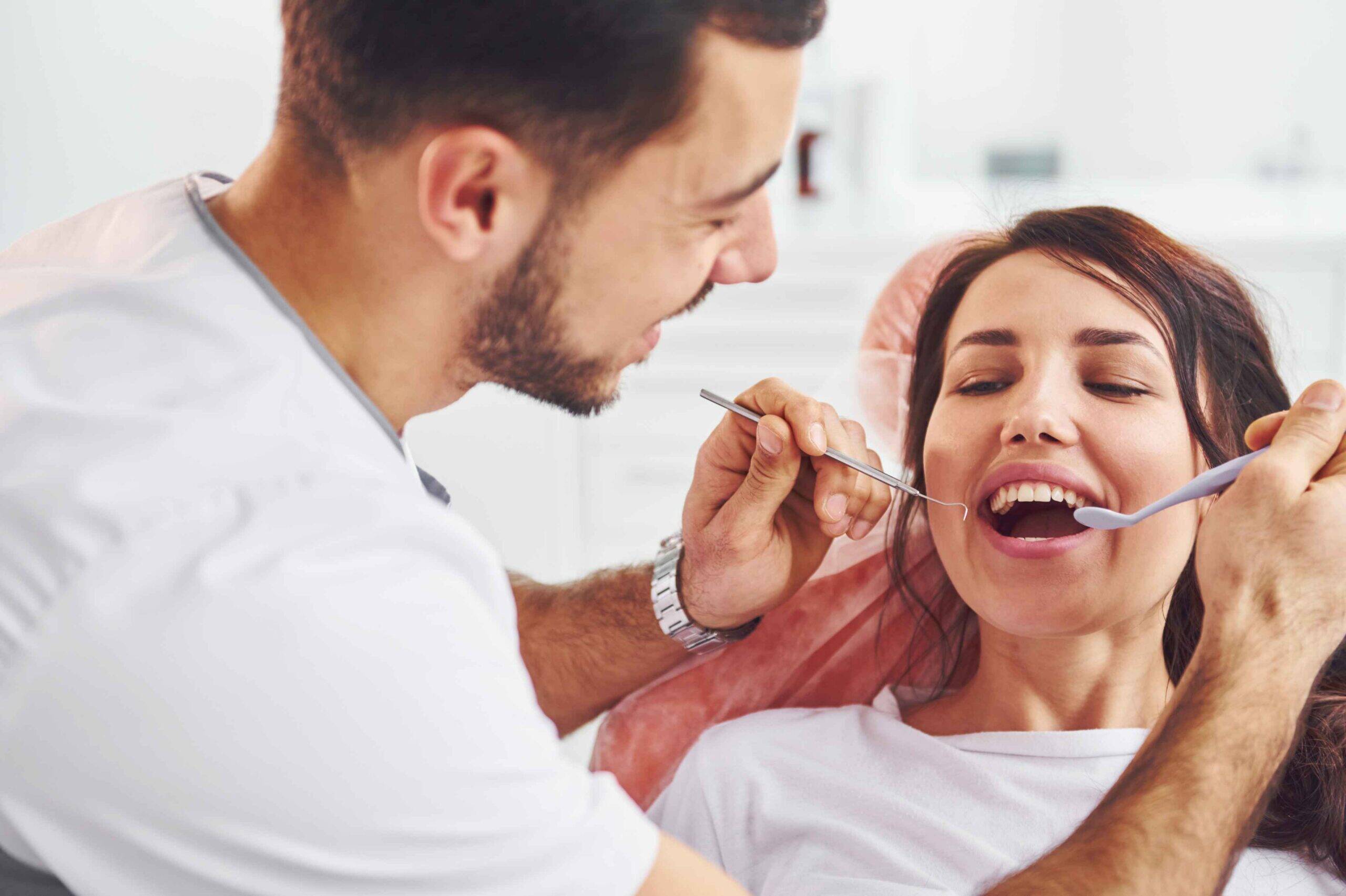 Dentist examining a smiling patient's teeth.