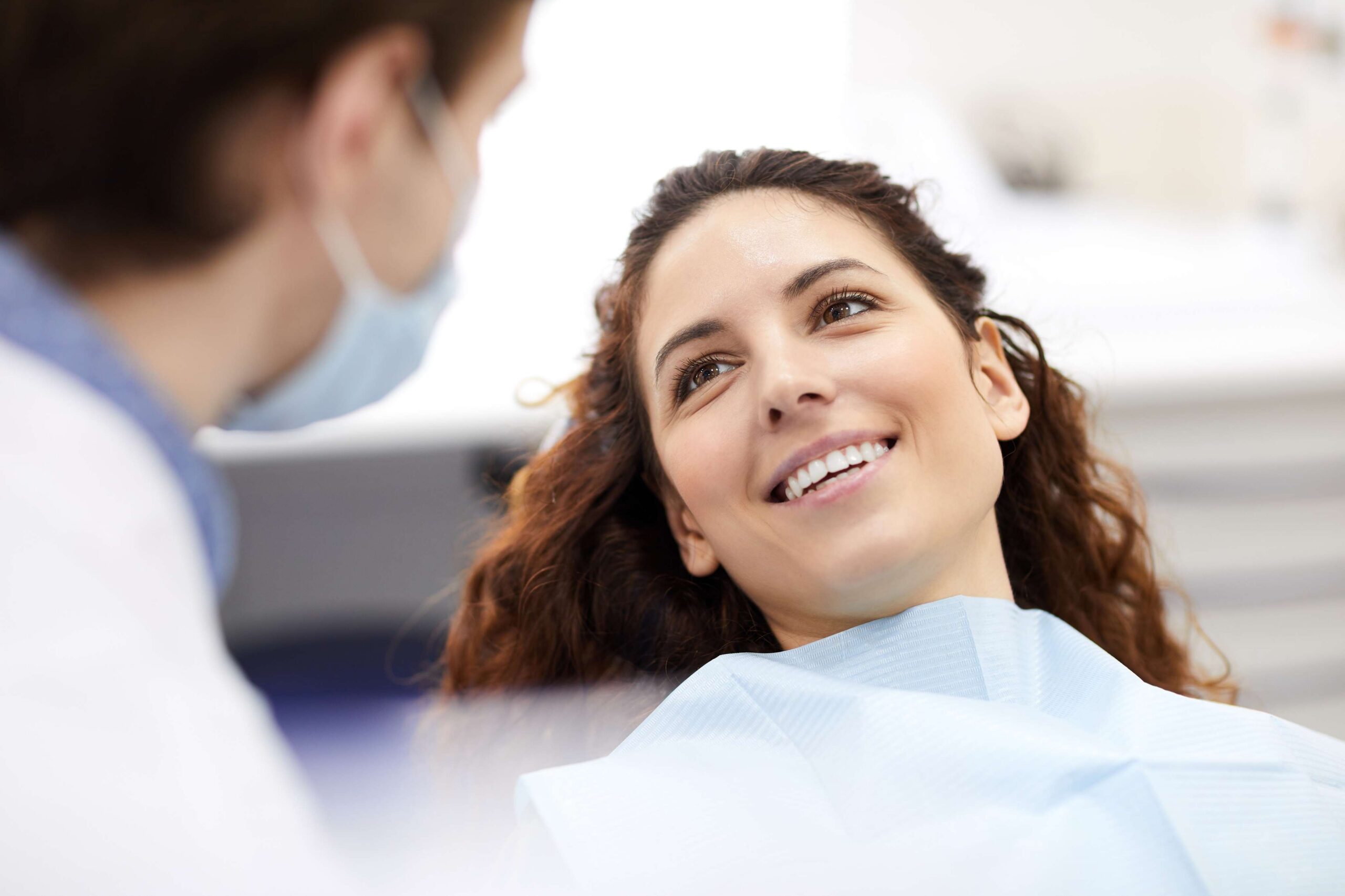 Smiling patient discussing veneers with dentist.